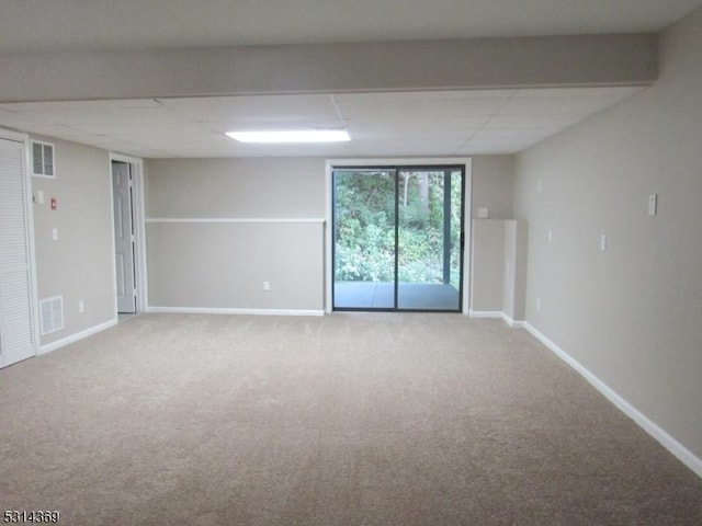 empty room with carpet and a paneled ceiling