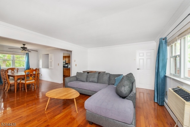 living room featuring ceiling fan, crown molding, wood-type flooring, and a baseboard radiator