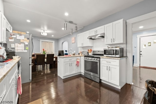 kitchen with white cabinetry, kitchen peninsula, appliances with stainless steel finishes, and dark wood-type flooring