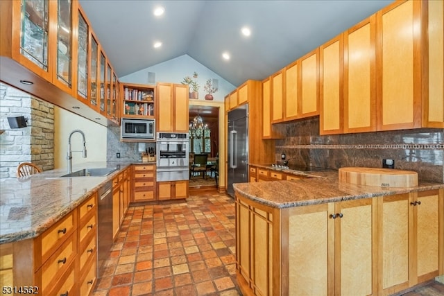 kitchen with built in appliances, sink, kitchen peninsula, decorative backsplash, and light stone countertops