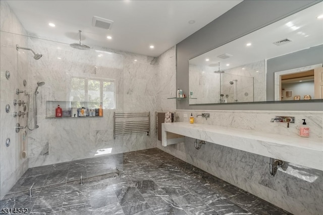 bathroom featuring a tile shower and a workshop area