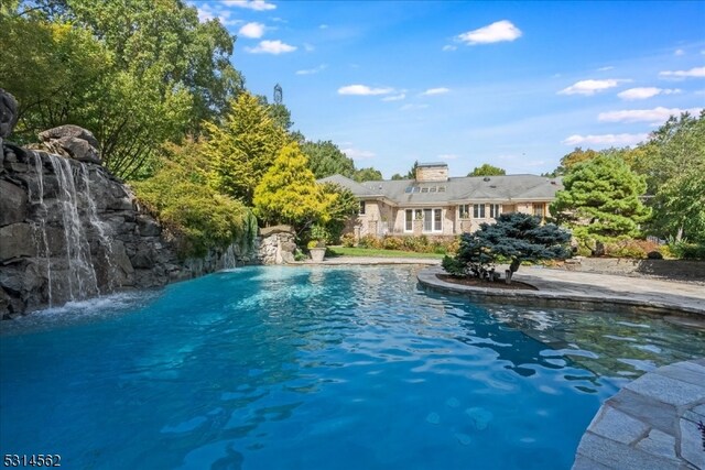 view of swimming pool with pool water feature