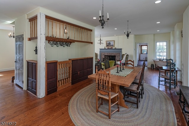 dining space with a chandelier, a fireplace, and wood-type flooring