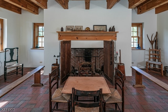 dining space featuring beamed ceiling and plenty of natural light