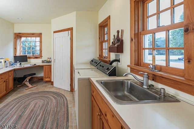 washroom featuring sink, washer and dryer, a healthy amount of sunlight, and light tile patterned floors