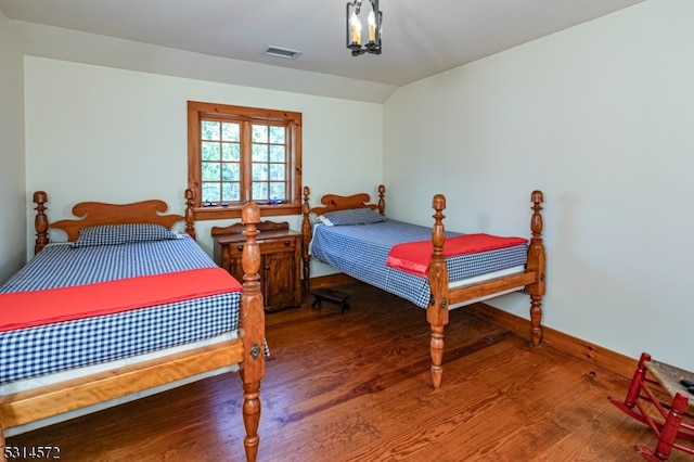 bedroom featuring vaulted ceiling and wood-type flooring