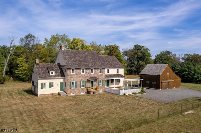 back of house featuring a yard, an outbuilding, and a garage