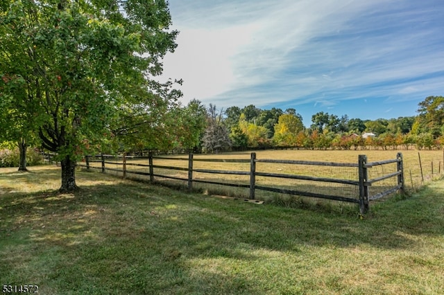 view of gate featuring a lawn and a rural view