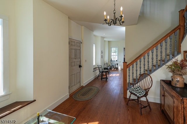 foyer with an inviting chandelier and dark hardwood / wood-style floors