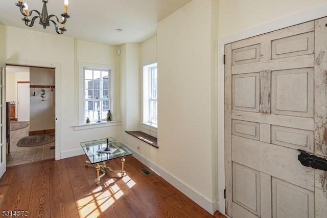 interior space with a notable chandelier and dark hardwood / wood-style floors