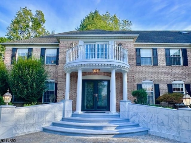 view of front of house with french doors and a balcony