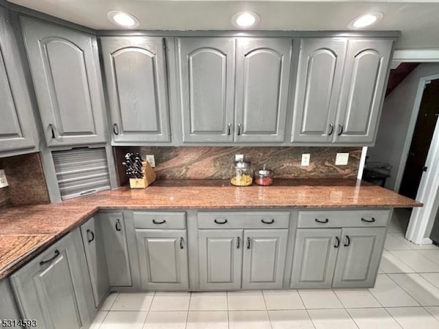 kitchen featuring gray cabinetry, light tile patterned floors, and tasteful backsplash