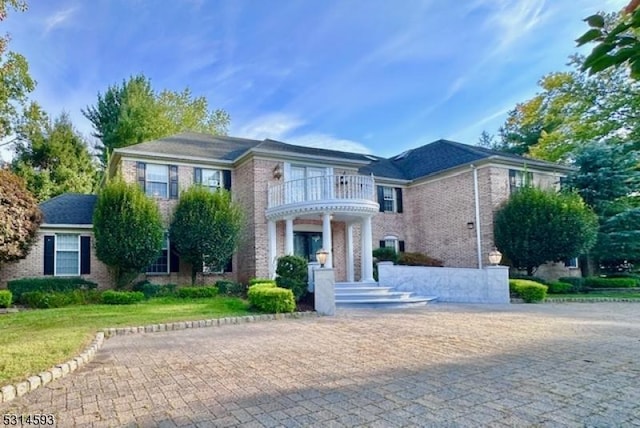 view of front of home featuring a balcony and a front yard