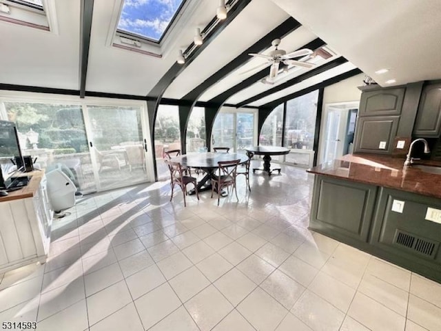 sunroom with vaulted ceiling with beams, ceiling fan, and sink