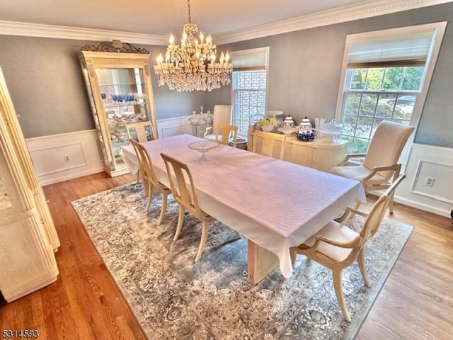 dining space with a chandelier, light hardwood / wood-style floors, and ornamental molding