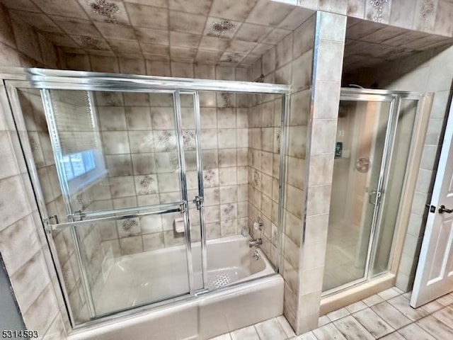 bathroom featuring combined bath / shower with glass door