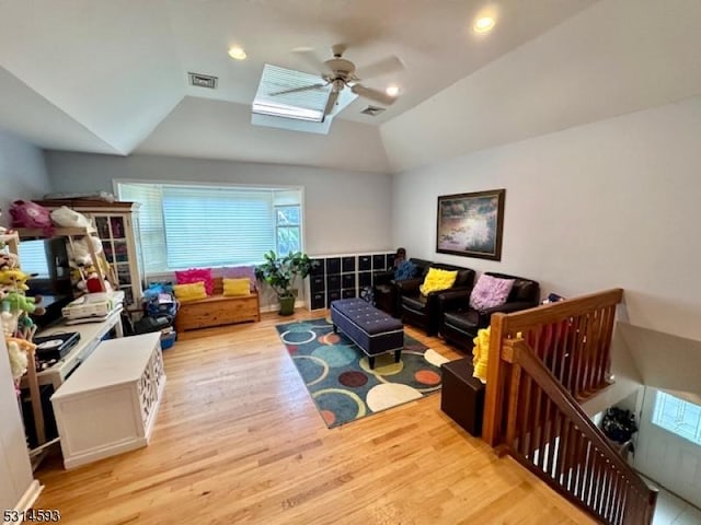 living room with ceiling fan, light wood-type flooring, and lofted ceiling