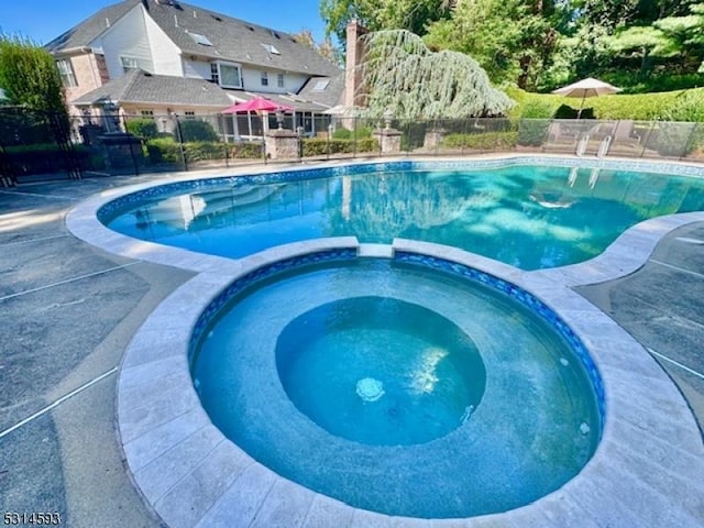 view of swimming pool featuring an in ground hot tub