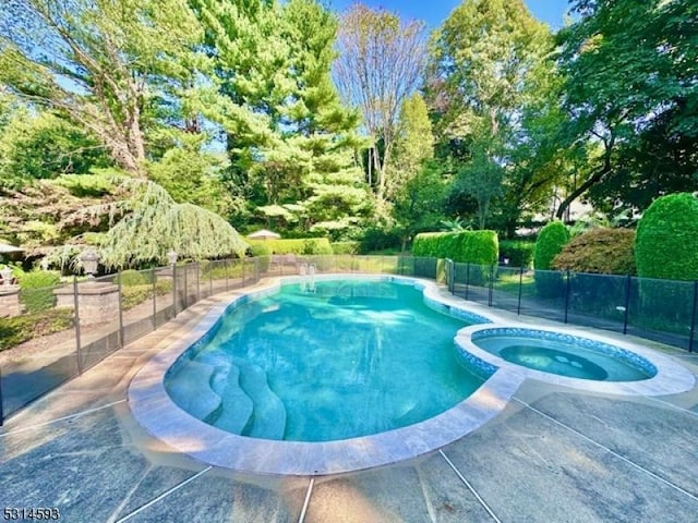 view of pool with an in ground hot tub