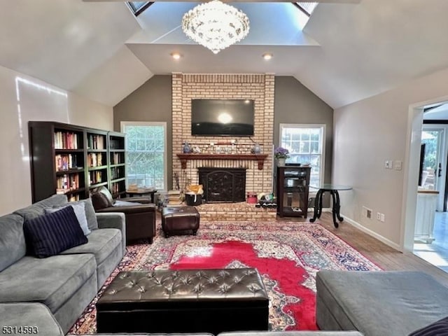 living room featuring a fireplace, hardwood / wood-style floors, vaulted ceiling, and a notable chandelier