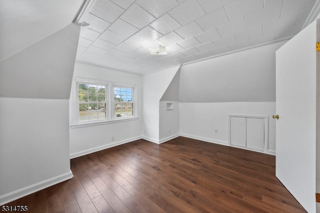 additional living space with vaulted ceiling and dark wood-type flooring