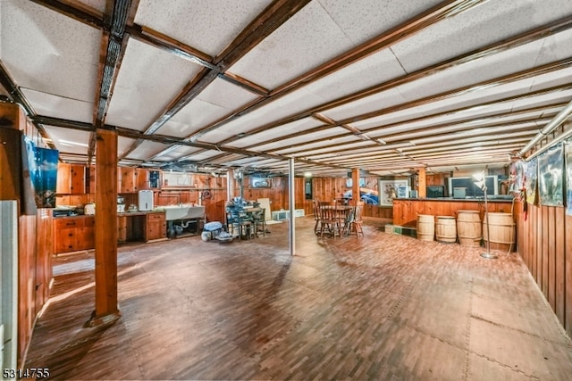 basement with wood walls and hardwood / wood-style floors