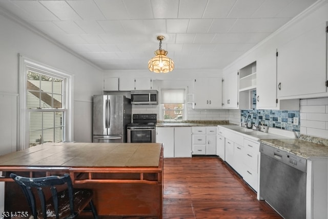 kitchen featuring stainless steel appliances, white cabinetry, dark hardwood / wood-style floors, and decorative light fixtures