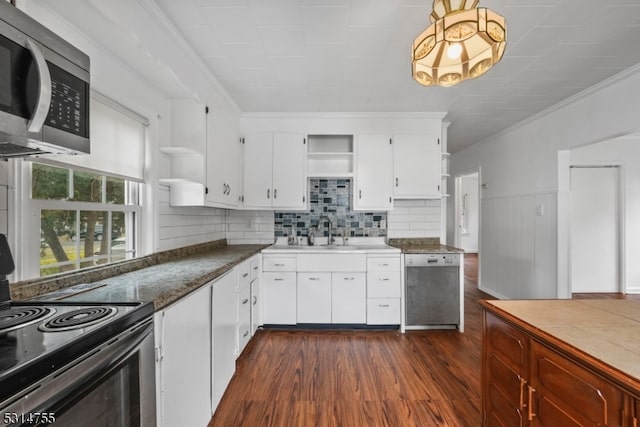 kitchen featuring dark hardwood / wood-style floors, white cabinets, decorative backsplash, appliances with stainless steel finishes, and crown molding