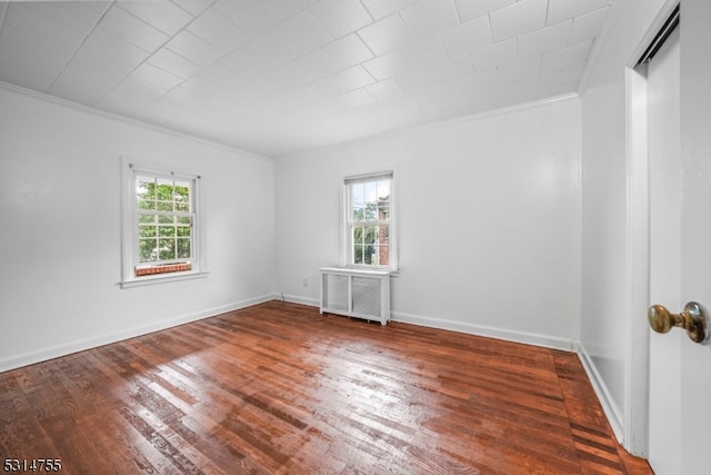 spare room with crown molding, hardwood / wood-style floors, and radiator heating unit