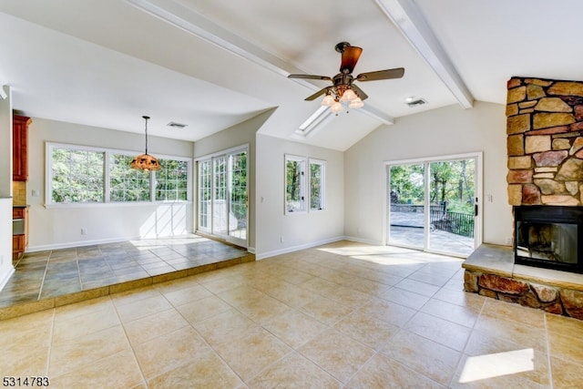 unfurnished living room featuring a fireplace, lofted ceiling with beams, ceiling fan, and a wealth of natural light