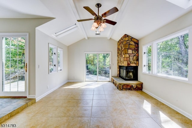 unfurnished living room with lofted ceiling with beams, ceiling fan, light tile patterned flooring, and a fireplace