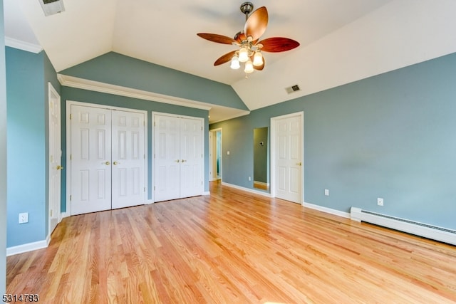 unfurnished bedroom with vaulted ceiling, a baseboard heating unit, ceiling fan, and light hardwood / wood-style flooring