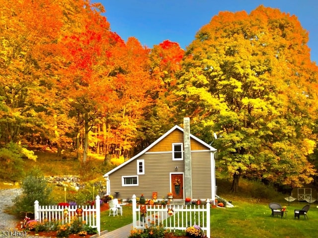 exterior space with a wooden deck, a front yard, and a fire pit