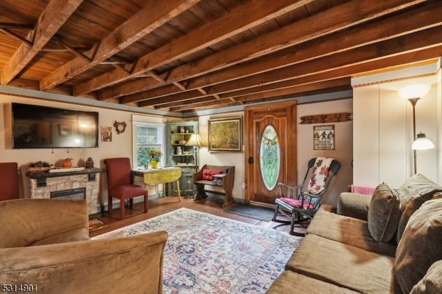 living room featuring wood ceiling, a stone fireplace, beam ceiling, and hardwood / wood-style floors