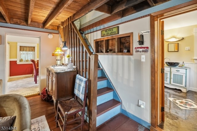 staircase featuring wooden ceiling and beam ceiling