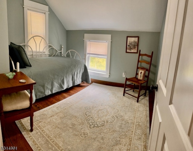 bedroom with wood-type flooring and vaulted ceiling