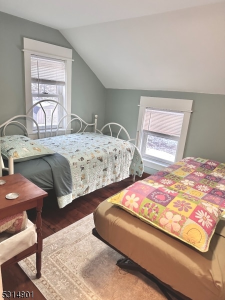 bedroom with vaulted ceiling and dark hardwood / wood-style flooring