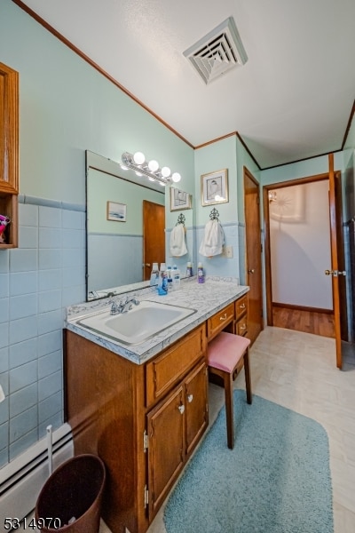 bathroom featuring a baseboard heating unit, tile walls, and vanity