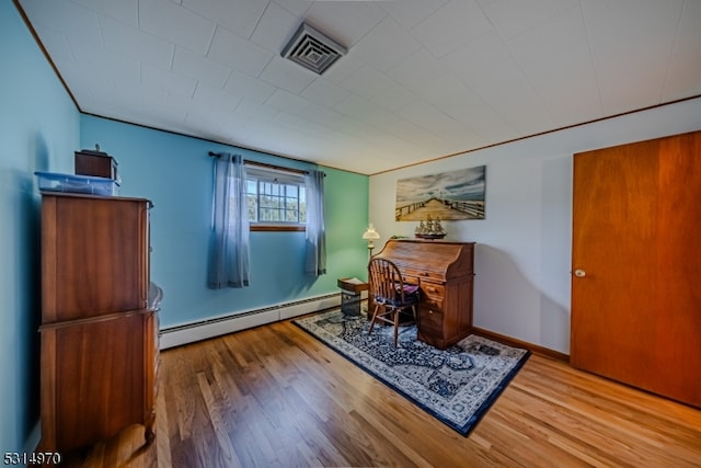 office space with wood-type flooring and baseboard heating