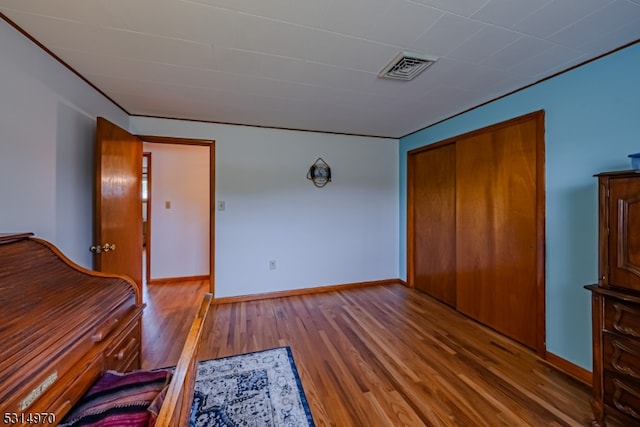 unfurnished bedroom featuring a closet and hardwood / wood-style floors