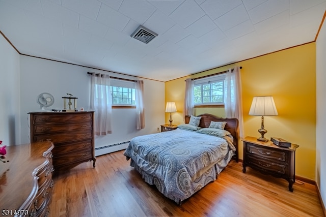 bedroom with wood-type flooring and a baseboard radiator