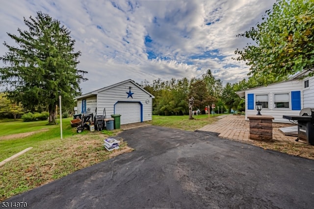 view of front facade featuring a front yard, an outbuilding, and a garage