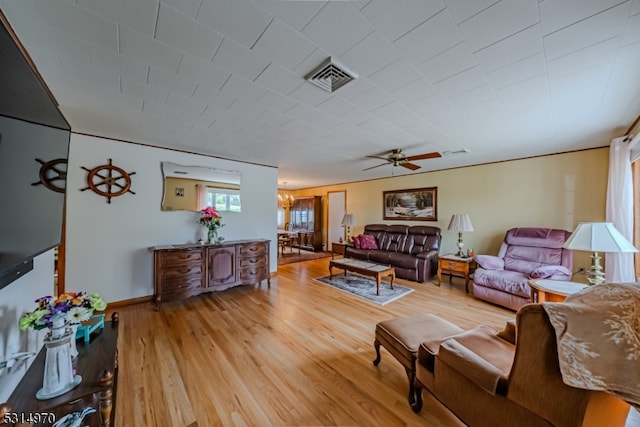 living room featuring ceiling fan with notable chandelier and light hardwood / wood-style floors