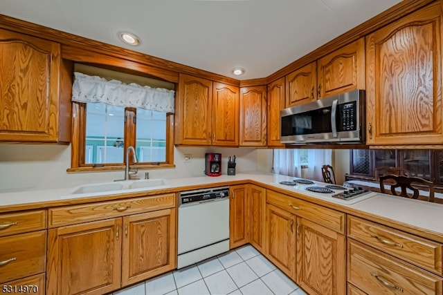 kitchen with white appliances, light tile patterned floors, and sink