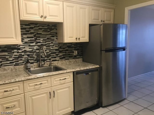 kitchen with stainless steel appliances, white cabinetry, and sink