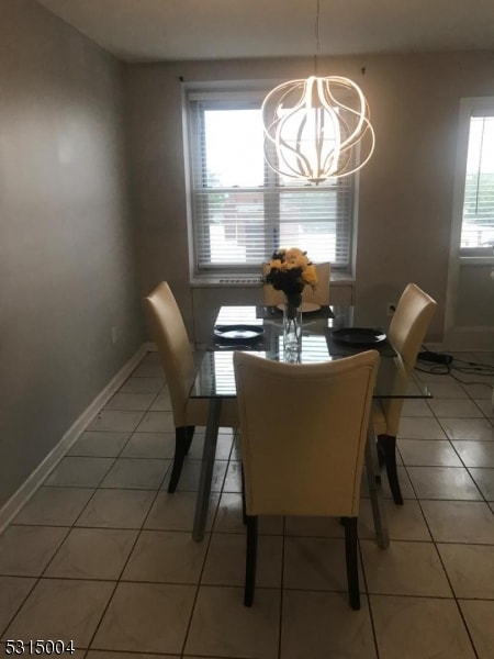 tiled dining space featuring a chandelier and a wealth of natural light