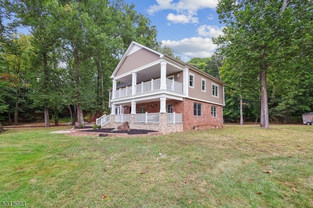 view of side of property with a balcony and a lawn