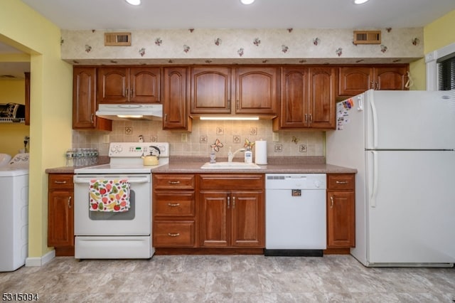 kitchen featuring backsplash, white appliances, and sink