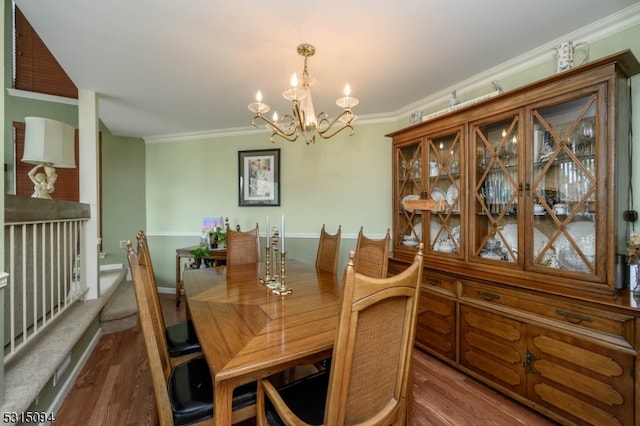 dining room featuring wood-type flooring, ornamental molding, and a notable chandelier