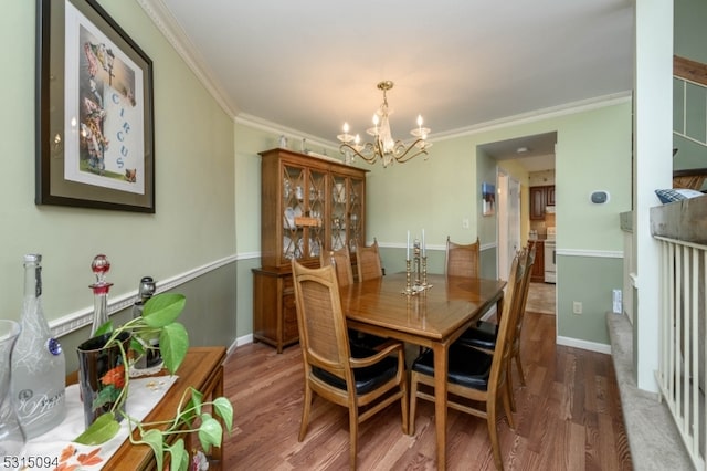 dining room with a notable chandelier, ornamental molding, and hardwood / wood-style flooring